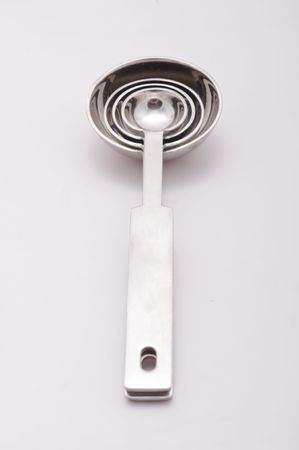 Stainless steel measuring spoons sit on white with room for copy spaceの写真素材