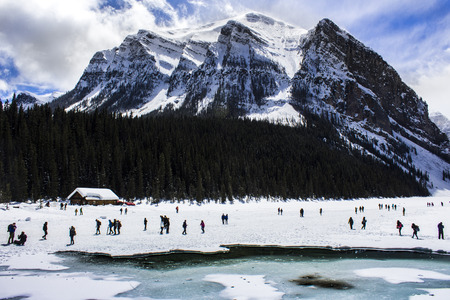 People playing on frozen Lake Louise in Alberta, Canada, on a snowy day.の写真素材