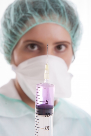 Nurse holding a syringe - isolated over whiteの写真素材