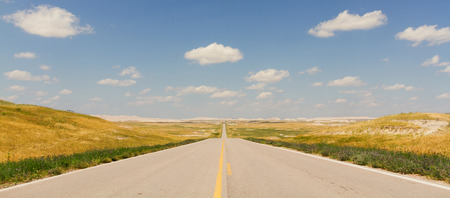 Horizontal Photo of an Ultra Wide North Dakota Highway with yellow lines, blue sky and cloudsの写真素材
