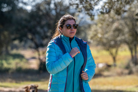 young girl in blue sportswear running and playing sports in nature