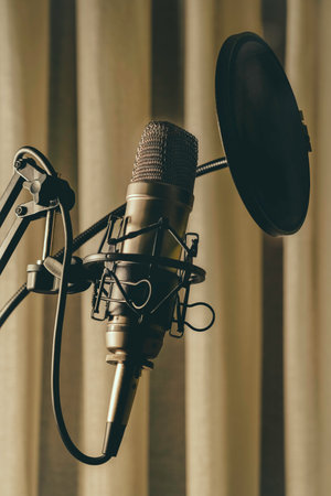 Studio condenser microphone with anti-pop filter and anti-shake mount with colored backlight blue. Side viewの写真素材