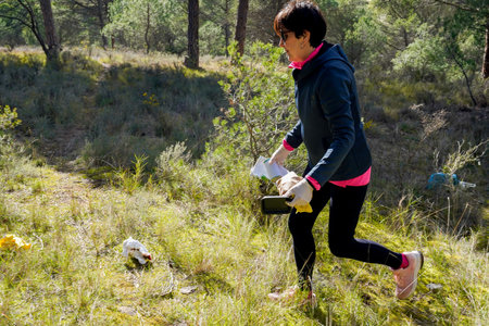 Adult woman picking up litter in natureの写真素材