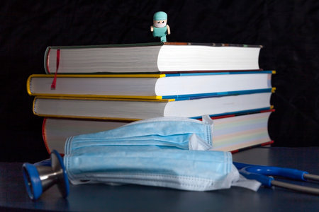 male nurse jumping on masks and stethoscope from some medical books.の写真素材