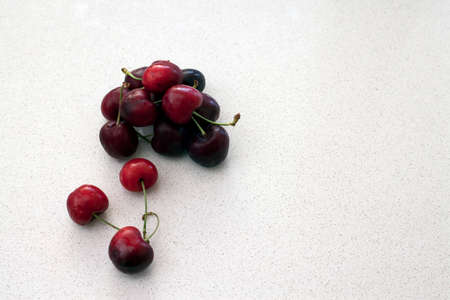 Red cherries on white speckled background, fruit, vegetable, healthy.の写真素材