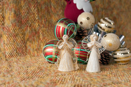 straw angels with Christmas decorations: silver bow, red balls with green and white lines, gold balls with stripes.の写真素材