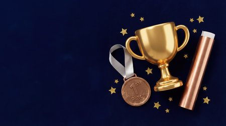 Gold trophy cup and first place medal on dark blue backgroundの素材