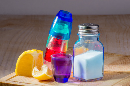 Shooter glasses of different colours stacked one in side of the other and upside down.の写真素材