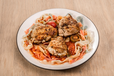Fettucchine pasta with a tomato sauce and friend chicken on a plate.の写真素材