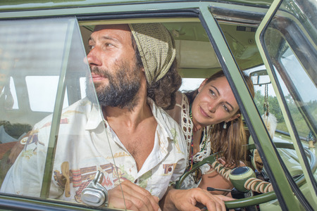 A young man and woman looks out of the window of their camper van as they head of on a journey.の写真素材