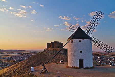 Windmill with the castle of Consuegra (Toledo) in the background, at sunsetの写真素材