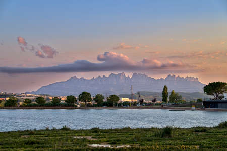 Parc de l'Agulla de Manresa, with the mountains of Montserrat at sunset with a nice cloud formationの写真素材