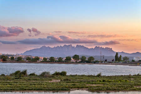 Parc de l'Agulla de Manresa, with the mountains of Montserrat at sunset with a nice cloud formationの写真素材