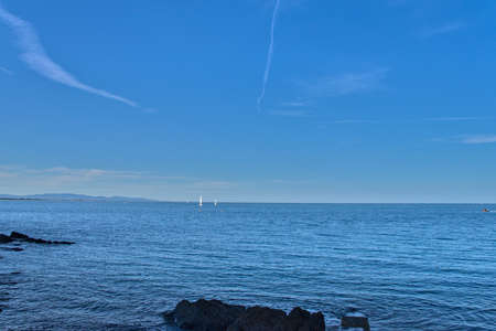 Sailing ship sailing over the horizon with calm seaの写真素材