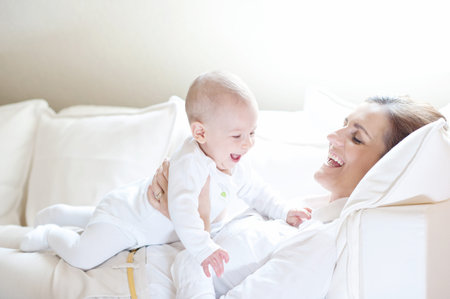 Happy mother holding her lovely smiling baby