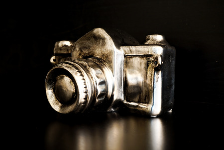 A modern version of a camera in silver and gold with black backgroundの写真素材
