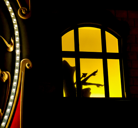 Las Vegas, Nevada: May 11, 2018:  A window lit up with shadow of a person drinking sitting in a chair with legs and high heels in the air inside  of the Paris Hotel and Casinoのeditorial素材
