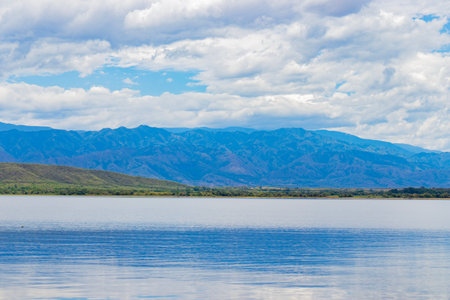 A body of water with a mountain in the background