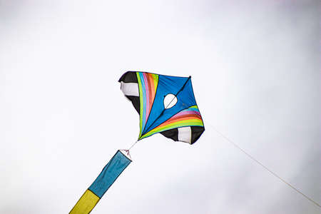 A person flying through the air while holding a colorful kiteの写真素材