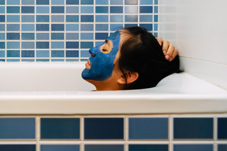 Woman with blue beauty mask in bathtub is relaxedの写真素材