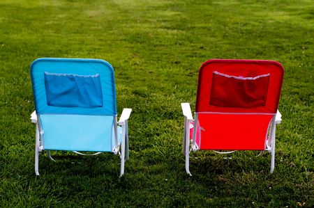 Two Chairs on Grass one red, one blueの写真素材