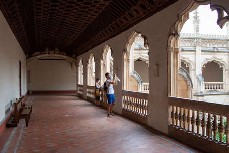 Toledo, Spain. August, 2020. A family wearing face mask to avoid Covid-19 takes photos and stares fixedly at the cloister of the Monastery of San Juan de los Reyes in old town Toledo.のeditorial素材