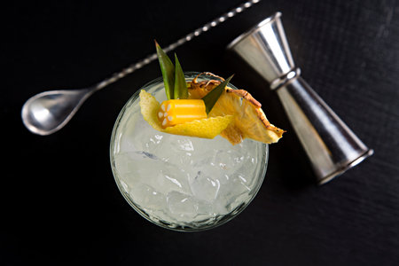 Cocktail with tropical decoration black background seen from above.