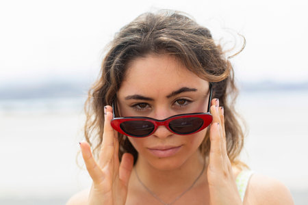 Portrait of young woman wearing sunglasses looking at cameraの写真素材