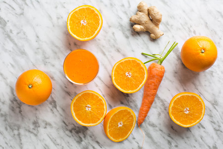 Healthy orange, carrot and ginger juice. Composition on white marble background seen from above.の写真素材