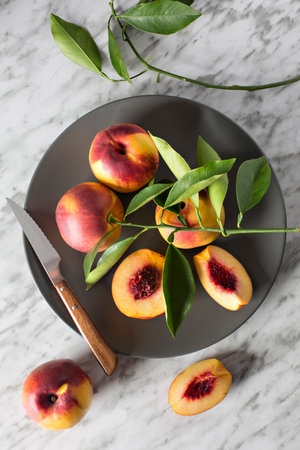 Dish with nectarines on gray marble background, top view.の写真素材