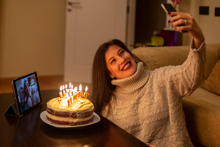 Woman celebrating her birthday remotely with her family.の写真素材