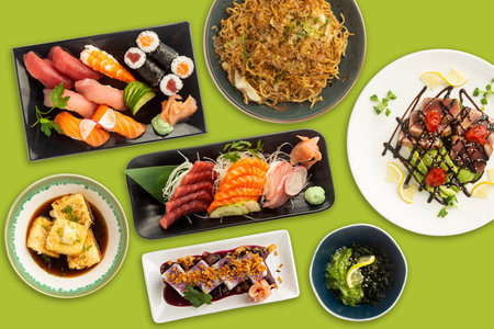 Very colorful and varied typical Japanese food viewed from above on a green background. Sushi, tofu, Tuna, Salmon.の写真素材