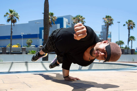 Young latin man urban acrobatic dancer on the street doing a performance.