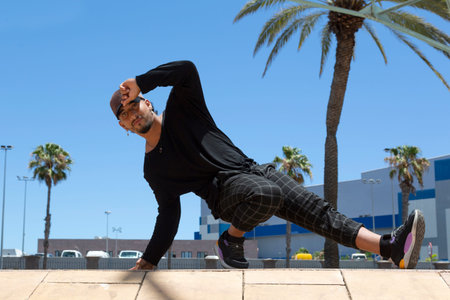 Young latin man urban acrobatic dancer on the street doing a performance.