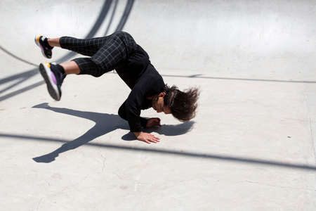 Young latin man performing street dance inside skating pit.の写真素材