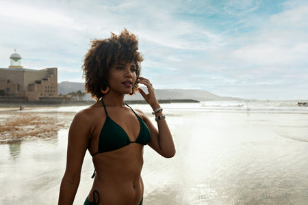 Portrait of a beautiful black woman in swimsuit with beach background.の写真素材