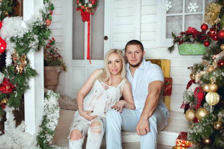 pregnant woman with her husband in the New Year interiorの写真素材