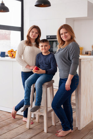 Middle-aged woman mom with daughter and son in the light roomの写真素材