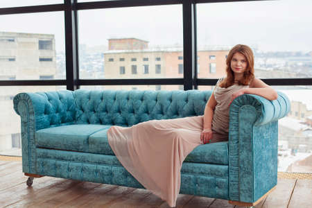 Young woman in beautiful dress in the light roomの写真素材