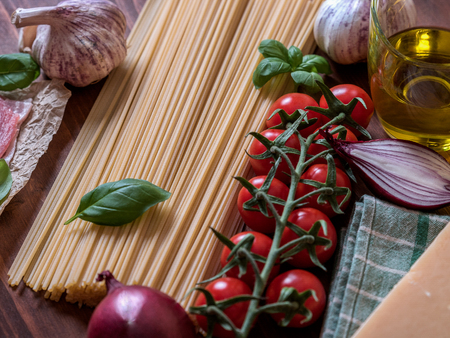 Italian pasta dish with basil, garlic,onion, bacon and tomatoesの写真素材