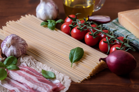 Italian pasta dish with basil, garlic,onion, bacon and tomatoesの写真素材