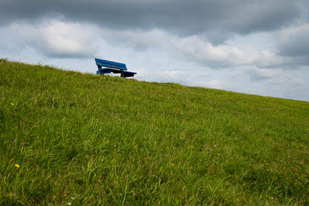 Still life picture of a blue bench on the dike in Petten (The Netherlands)の写真素材