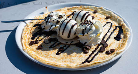 Dame blanche (vanilla ice with hot chocolate) pancake on a plate served in a restaurantの写真素材