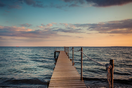 Wooden pier on the seashore. Blue sky with clouds. On the Baltic Sea coast of Denmark.の写真素材