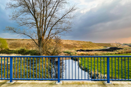 A view of a small river from a bridge over a dike.の写真素材