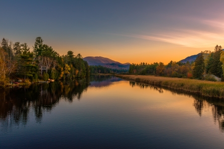 Autumn scenery at sunset reflected in the water of the riverの写真素材
