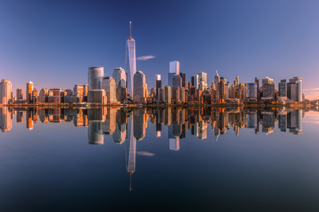 Lower Manhattan skyline panorama over East River with reflection at sunset 2の写真素材