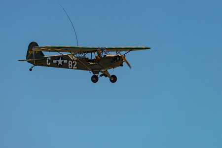 READING, PA - JUNE 3, 2017: PIPER L-4H "GRASSHOPPER" in flight during World War II reenactment at Mid-Atlantic Air Museumのeditorial素材