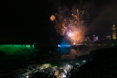 Niagara Falls lit at night by colorful lights with fireworksのeditorial素材