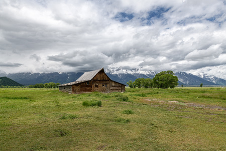 Old mormon barn in Grand Teton Mountains with low clouds. Grand Teton National Park, Wyoming, USA.の写真素材
